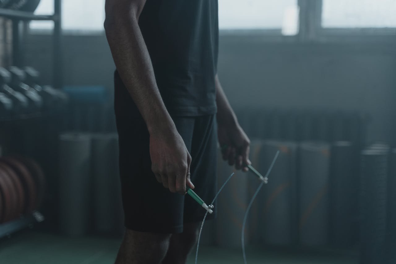 Man in Black Tank Top Holding Green and White Stick